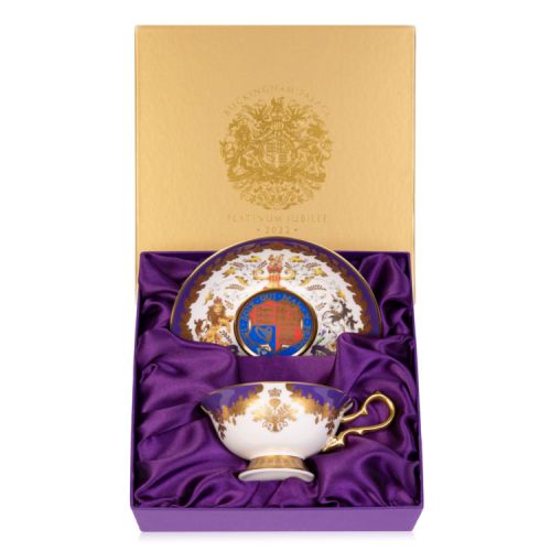 Platinum Jubilee Limited Edition Teacup and Saucer. The saucer displays the coat of arms and is surrounded by a purple and gold leaf design. The teacup has a gold handle and gold base and EIIR on the inside of the cup.