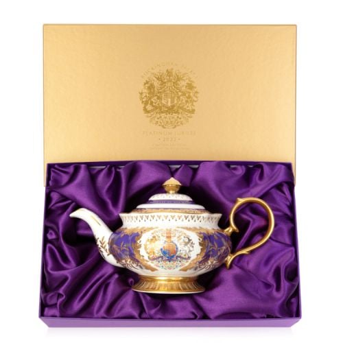 Teapot featuring a gold handle and a coat of arms at the centre. The base and lid are gold and the teapot features a purple and gold leaf design throughout.