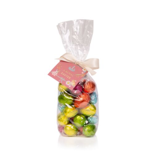 Clear bag of chocolate foiled eggs in colourful foils such as orange, yellow, pink, green and blue. Wrapped in an oyster bow and a pink label.