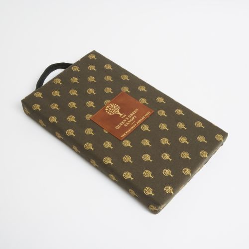 Green rectangular gardening kneeling pad printed with gold trees. At the centre of the kneeling pad is a leather label printed with a gold tree and the words 'The Queen's Canopy The Platinum Jubilee 2022'