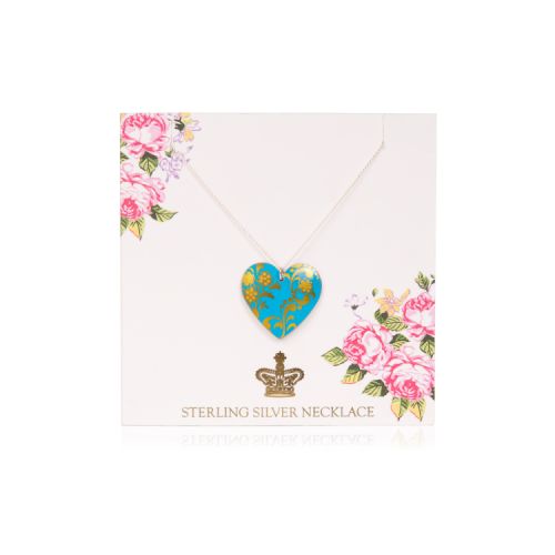 Blue heart pendant on a chain. It is on a pale pink backing card decorated with pink roses and a gold crown