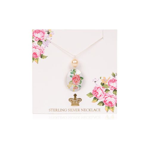 Oval pendant with a rose design and topped with a pearl on a chain. It is on a pale pink backing card decorated with pink roses and a gold crown