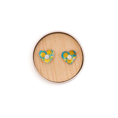 Blue heart earrings with a gold design in a small round tin.