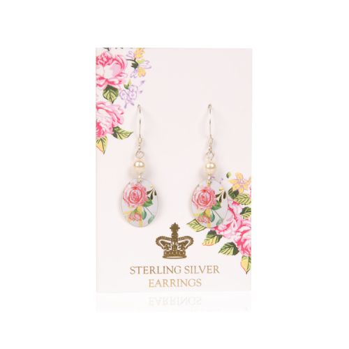 Oval drop earrings decorated with a pink rose design and topped with a pearl. It is on a pale pink backing card decorated with pink roses and a gold crown