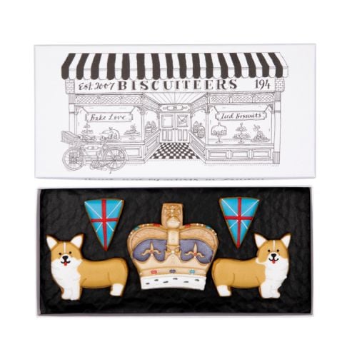 Iced biscuits shaped as flags, corgis and a crown in an illustrated box