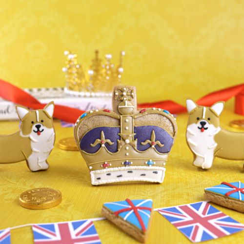 Iced biscuits shaped as flags, corgis and a crown in an illustrated box