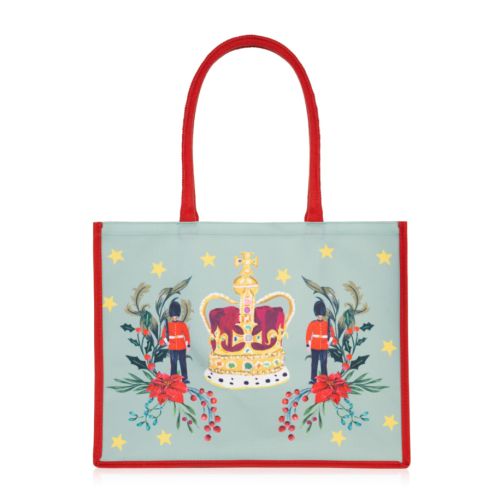 tote bag with crown, gaurdsman and christmas florals decorated with stars on a green background and red piping and handles.