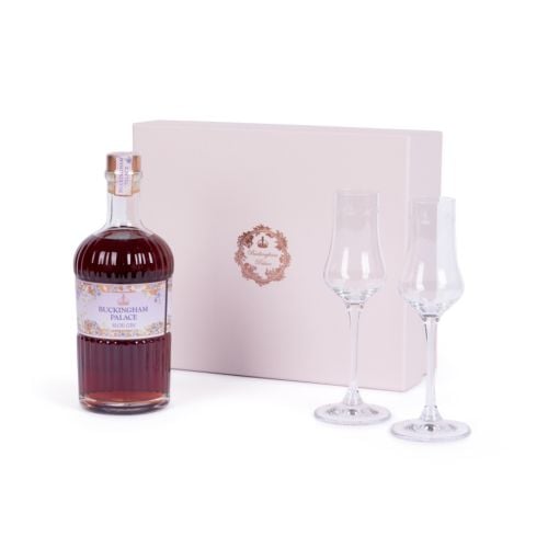 A bottle of Buckingham Palace Sloe Gin, with a pink gift box and two sloe gin glasses that make up the gift set. 