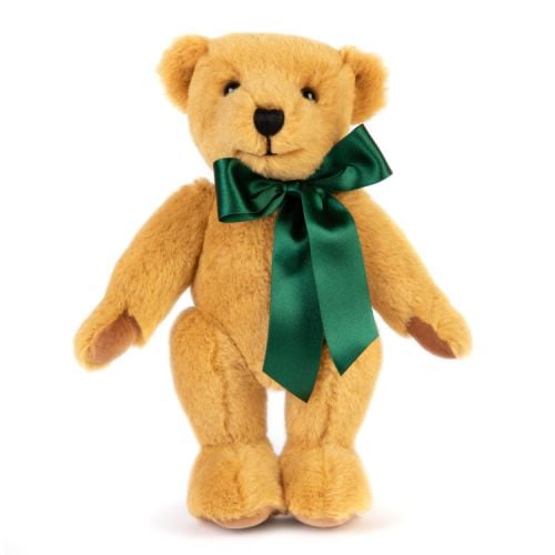 Merrythought Teddy Bear wearing a green satin ribbon round its neck. The left foot has 'Windsor Castle' and the Tudor Rose embroidered in gold thread. On the right foot is a label stating that the bear is exclusively made for Windsor Castle by Merrythough