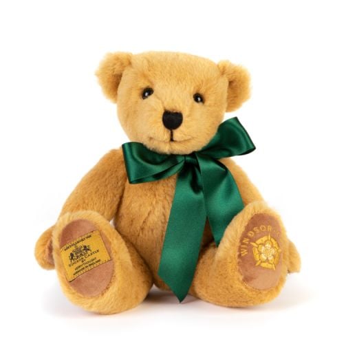 Merrythought Teddy Bear wearing a green satin ribbon round its neck. The left foot has 'Windsor Castle' and the Tudor Rose embroidered in gold thread. On the right foot is a label stating that the bear is exclusively made for Windsor Castle by Merrythough
