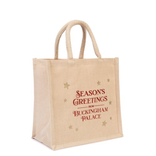 Reusable juco bag in neutral colour. Red script and gold stars decoration. 