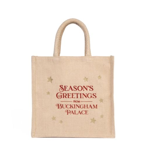 Reusable juco bag in neutral colour. Red script and gold stars decoration. 