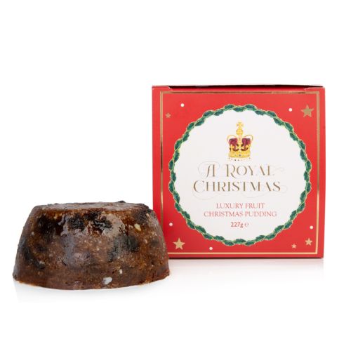 packaging box next to christmas pudding. box includes description and gold foil stars
