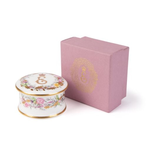 Fine bone china pillbox decorated with Princess Elizabeth's cypher as the central motif. Surrounding the cypher is floral arrangements, cherubs and feathers. Finished with gold leaf. 