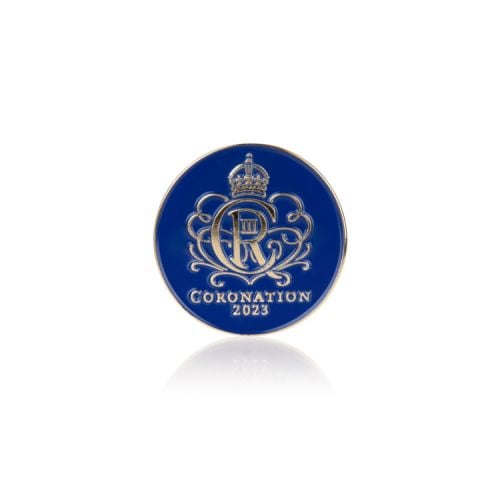 Blue pin badge with King Charles III's cypher in gold.