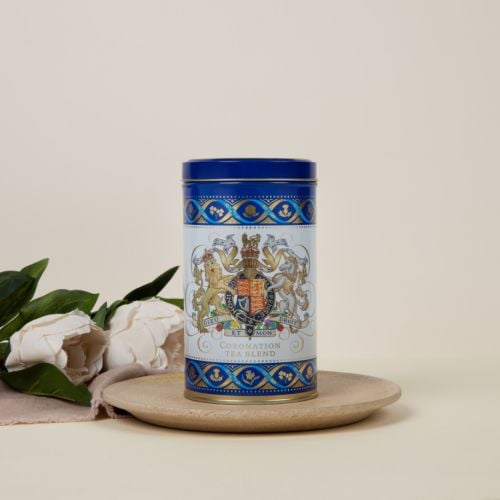 Blue and white tea caddy featuring the Royal Coat of Arms. The crest is framed with a border of thistles, roses, shamrocks and daffodils.