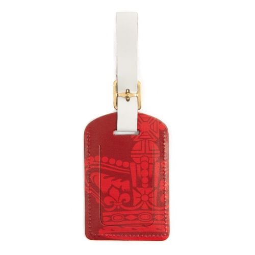 Luggage tag in red with white buckle and decorative crown and the words Buckingham Palace on the bottom of the tag in gold