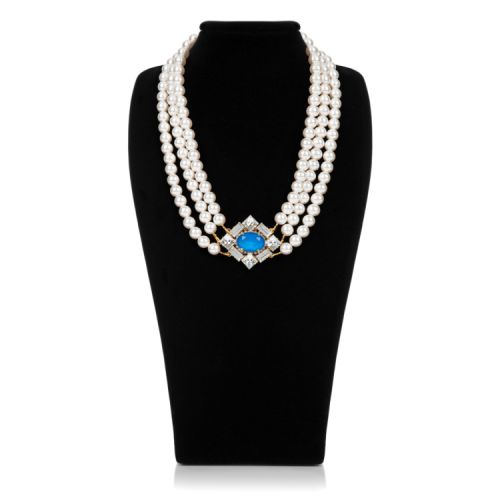 Three strand pearl necklace with blue crystal and square clear crystals surround. 