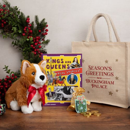 Seasons Greetings bag with Kings and Queens book, bag of chocolate coins and a soft toy corgi with red ribbon. Buckingham Palace written on both the corgi and the bag. 