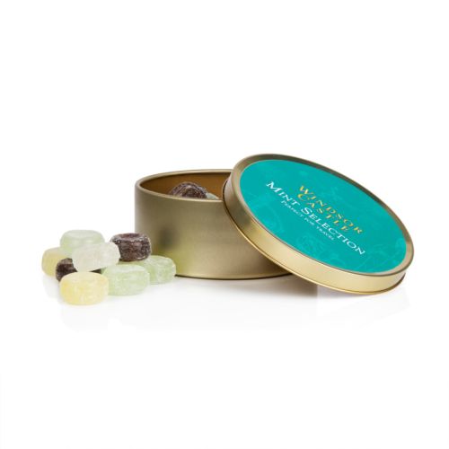 Top of mint selection tin. Gold tin with turquoise label and white illustrations featuring items such as a teacup, a crown and a fork. 