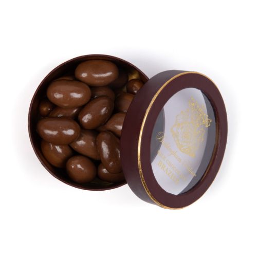 Lid of chocolate brazil nut box with view to inside of packaging with the chocolate brazil nuts seen. wording with the buckingham palace crest in gold foil and maroon lining.