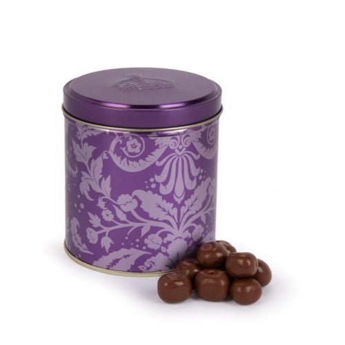 Purple tin with acanthus print and pile of ginger coated in chocolate.