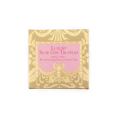 A golden patterned box with a pink centre with dark pink text, with "Luxury Sloe Gin Truffles, nade using Buckingham Palace Sloe Gin" in writing. 