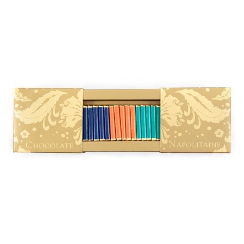 An open rectangular shaped box featuring a gold pattern, revealing at the centre, rows of individually wrapped foil chocolates with three colours and flavours, milk chocolate (dark blue), orange milk chocolate (orange) and mint dark chocolate (turquoise).