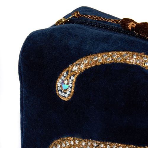 Blue velvet toiletries bag deaturing gem studded snake design. 