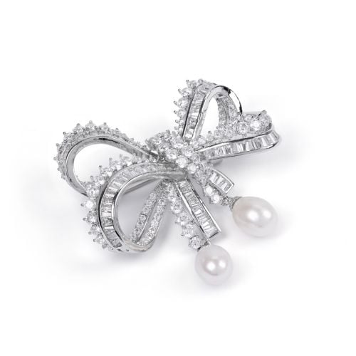 Silver gem studded bow shaped brooch with pearl drop detail. 