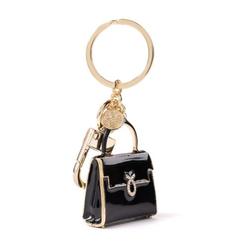 Black and gold bag charm in the shape of a Launer handbag