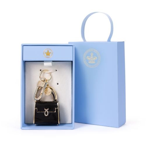 Black and gold bag charm in the shape of a Launer handbag