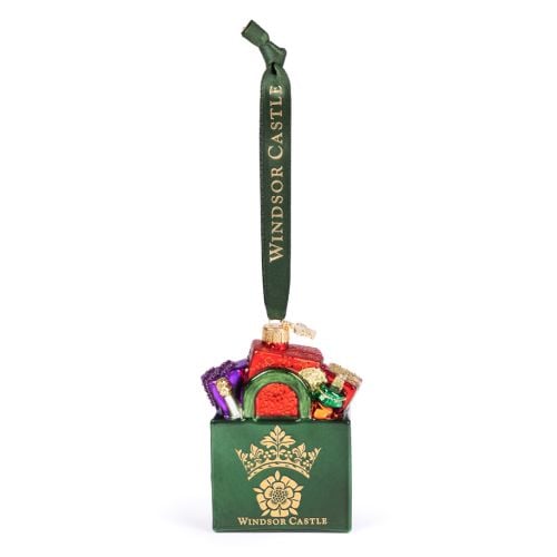 Green Glass Windsor Castle Christmas tree ornament shaped like a gift bag filled with colourful wrapped presents. The ornament features a gold crown emblem and the words "Windsor Castle” on the front. A green hanging ribbon with gold “Windsor Castle” lett