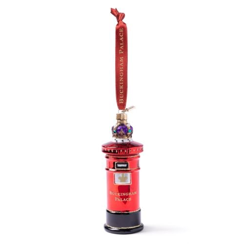 Red glass post box Christmas decoration with ‘Buckingham Palace’ lettering, gold trim, crown jewel detail and red ribbon hanger with 'Buckingham Palace' lettering in gold. 