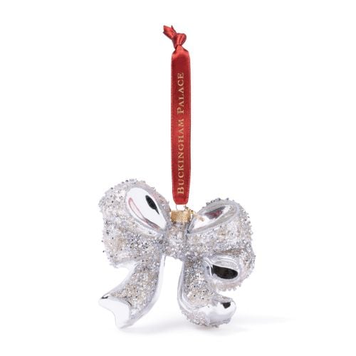 Silver glass bow decoration with glitter detailing, suspended from a red Buckingham Palace ribbon.