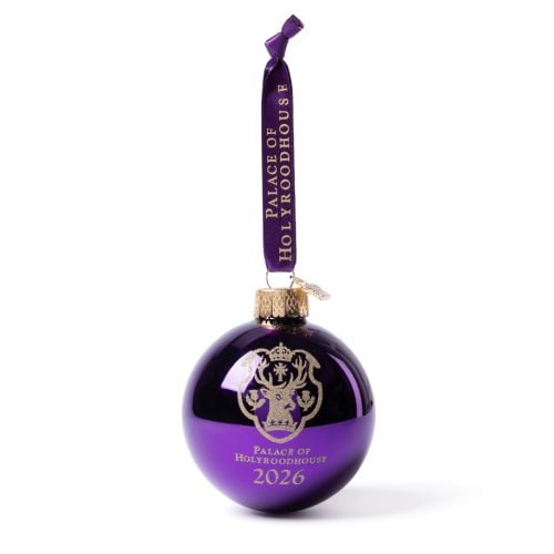 Palace of Holyroodhouse 2026 glass bauble in deep purple with gold crest and text, suspended from a ribbon printed ‘Palace of Holyroodhouse’.