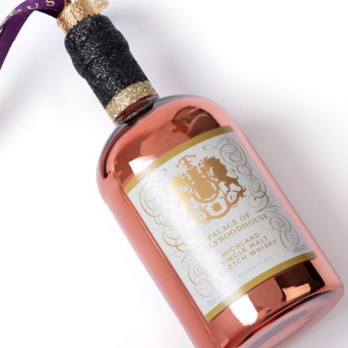 Palace of Holyroodhouse whisky bottle glass decoration with rose gold finish, hanging purple ribbon and Highland single malt Scotch whisky label.
