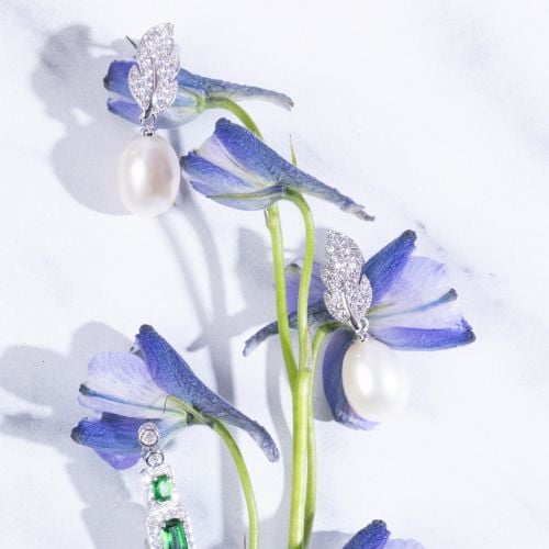 Pearl drop earrings with crustal studed feather design set in silver. 