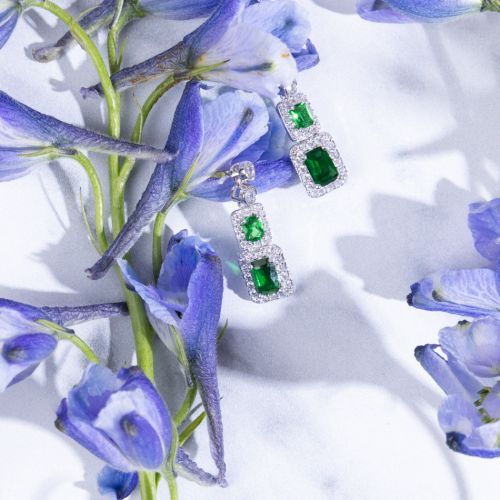 Emerald crystal cut drop earrings featuring two rectangular emeralds bordered by crystals.
