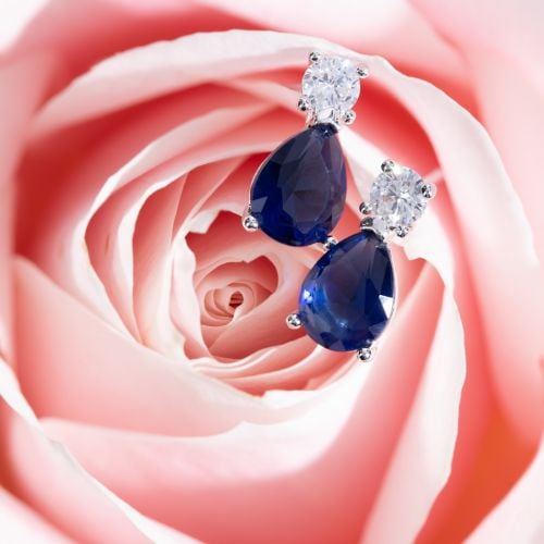 Blue crystal teadrop shaped stud earrings with crystal stud above in silver. 