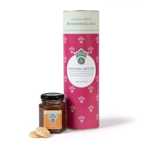 The Royal Pantry Windsor Castle savoury gift set, comprising a jar of caramelised onion chutney and mature Cheddar savoury bites, presented beside a pink cylindrical tube with crown motif.
