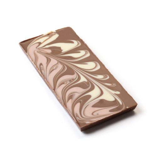 Front of “Milk Chocolate Stardust” chocolate bar from The Royal Pantry, Buckingham Palace. The deep blue packaging features a white crown emblem and decorative motif, with a window revealing marbled milk, white, and pink strawberry chocolate swirls.