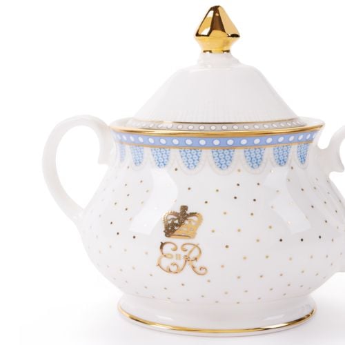 White fine bone china sugar bowl, featuring a blue scalloped border with gold trim, gold polka dot accents, and a decorative royal-style crest on the cup, With a gold topped lid and two handles. 