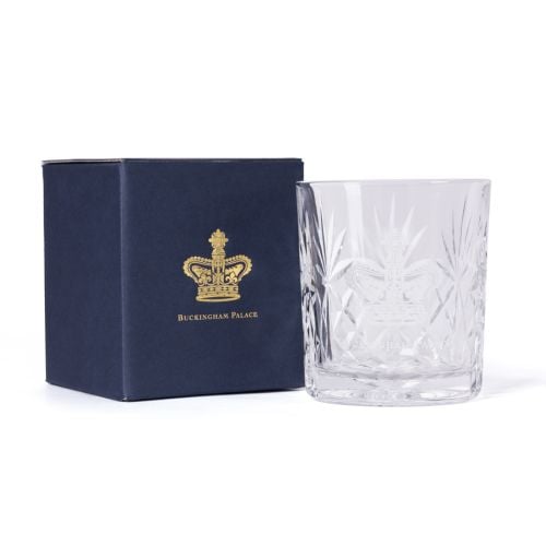 Clear cut-glass tumbler engraved with the Buckingham Palace crest, shown beside a navy box with gold crest and text.