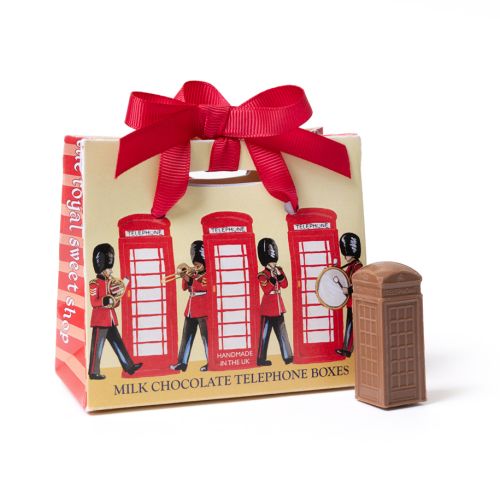 Gift box of milk chocolate telephone boxes with red ribbon handle, decorated with Guards band and red London telephone boxes; a single chocolate shaped like a telephone box stands beside the box.
