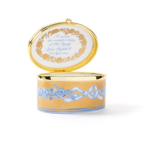 Queen Elizabeth II 90th Birthday Limited Edition Oval Box in blue and gold next to gold Buckingham Palace presentation box.