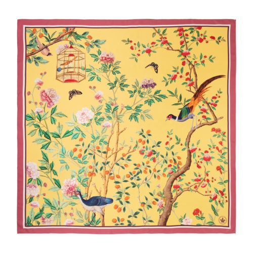 Yellow floral scarf featuring illustrated birds, flowering branches, berries and a hanging birdcage, finished with a pink border.