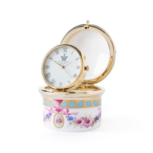 Open Buckingham Palace porcelain pillbox clock featuring a gold-tone analogue clock with Roman numerals, floral bone china base and hinged lid with gold trim.