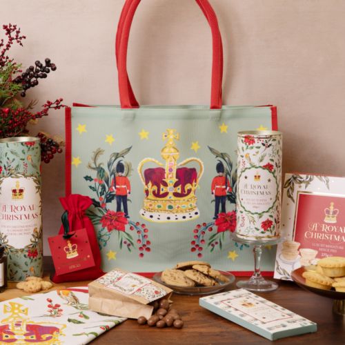 bag with decorative christmas illustrations surrounded by contents of the bag including festive treats to eat and tea towel