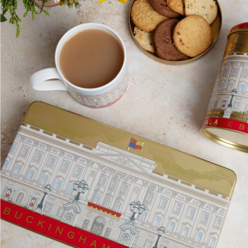 Open rectangular tin of assorted biscuits. On the lid is an illustration of the façade of Buckingham Palace.